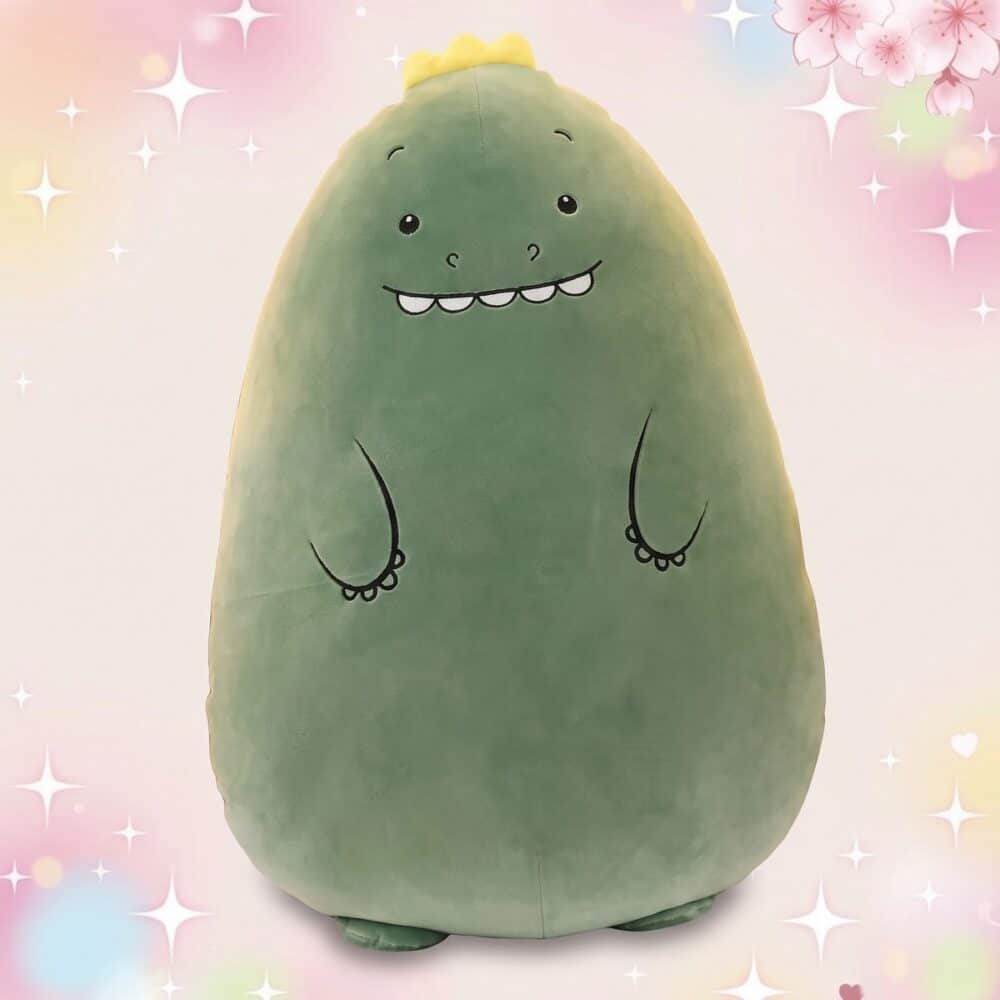 Une grande peluche dinosaure géante verte, toute ronde et douce, avec un petit visage souriant et des bras dessinés, sur un fond rose pastel avec des étoiles brillantes.
