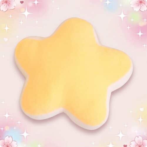 Un coussin kawaii étoile jaune en forme d’étoile, doux et moelleux, posé sur un fond rose décoré de petites fleurs et de brillants.