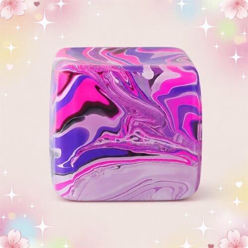 Un anti-stress squishy cube sensoriel marbré violet, rose et blanc, en forme de petit cube doux à presser, posé sur un fond pastel décoré d’étoiles et de fleurs.