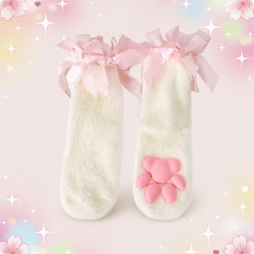 Une paire de Chaussettes kawaii avec coussinets 3D blanches et douces, avec de gros nœuds roses en haut et une patte rose sur le pied, sur fond pastel décoré d’étoiles et de fleurs.