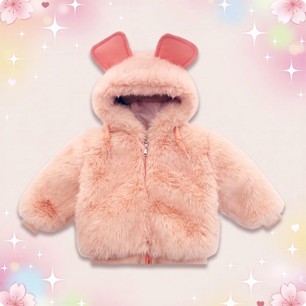 Un manteau à fourrure avec des oreilles pour enfant rose pâle, tout doux, avec capuche et petites oreilles, posé sur un fond pastel décoré de cœurs et d’étoiles.