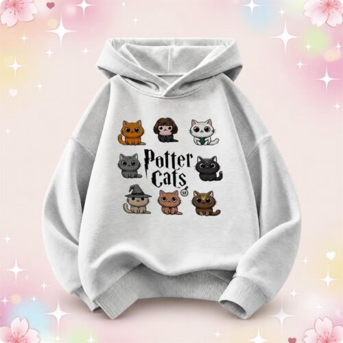 Un pull à capuche kawaii pour enfant Potter Cats gris clair, avec des petits chats rigolos imprimés sur le devant, posé sur un fond rose et pastel décoré d’étoiles et de cœurs.