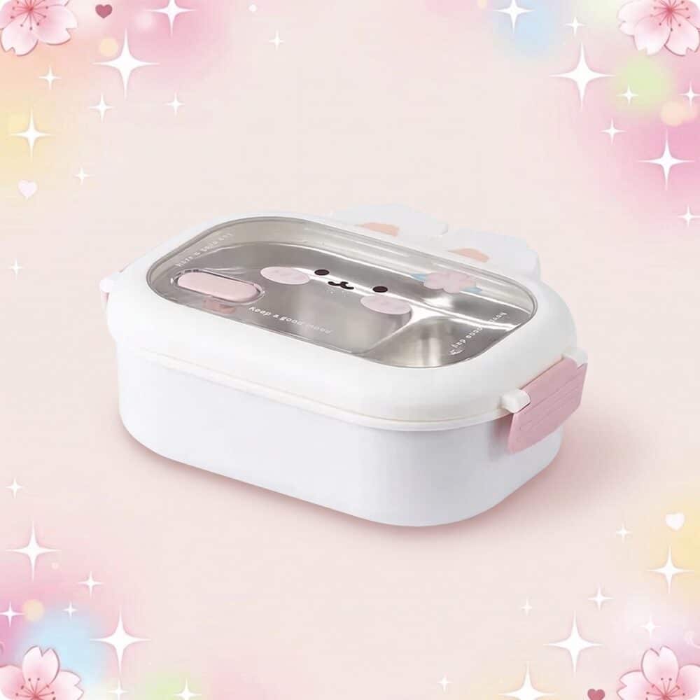 Une lunchbox kawaii en forme de lapin en acier inoxydable blanche et rose, avec un couvercle transparent décoré d’un petit visage de lapin, posée sur un fond rose pastel avec des étoiles.