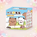 Une boîte Blind Box surprise figurine du couple Bubu et Dudu, décorée de personnages adorables et présentant plusieurs figurines à collectionner, sur un fond pastel fleuri.