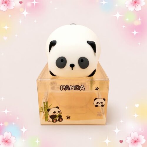Un mochi squishy panda blanc et noir du lot de 2 mochi squishies pandas dodus en coffret, présenté dans une boîte transparente sur un fond pastel décoré de fleurs et d’étoiles.