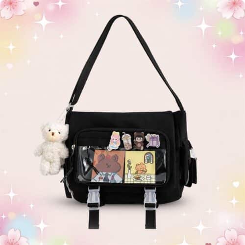 Un sac Kawaii à bandoulière avec poche transparente en nylon noir, décoré d’autocollants et accompagné d’un petit ours en peluche, présenté sur un fond pastel fleuri.