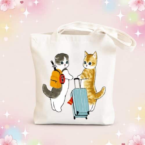 Un sac kawaii Mofusand réutilisable venu du Japon, blanc avec deux chats dessinés, dont l’un porte un sac à dos et l’autre tire une valise bleue, sur un fond pastel décoré de fleurs et d’étoiles.
