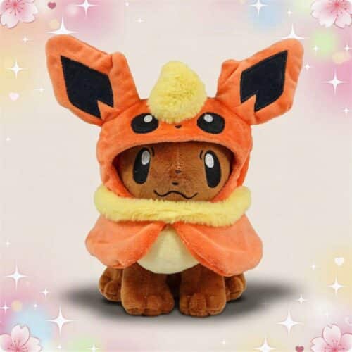 Une peluche Pokémon Evoli déguisé en ses évolutions, vêtue d’un costume orange avec de grandes oreilles et une collerette jaune, posée devant un fond pastel décoré de fleurs et d’étoiles.
