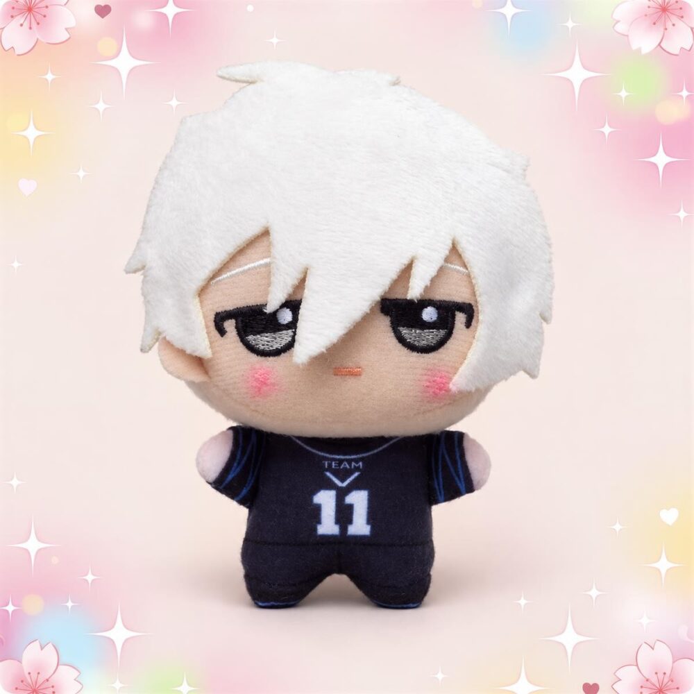 Un porte-clés peluche Nagi de Blue Lock représentant un petit personnage aux cheveux blancs, vêtu d’un maillot de football noir, sur un fond rose décoré d’étoiles et de fleurs.