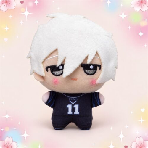 Un porte-clés peluche Nagi de Blue Lock représentant un petit personnage aux cheveux blancs, vêtu d’un maillot de football noir, sur un fond rose décoré d’étoiles et de fleurs.