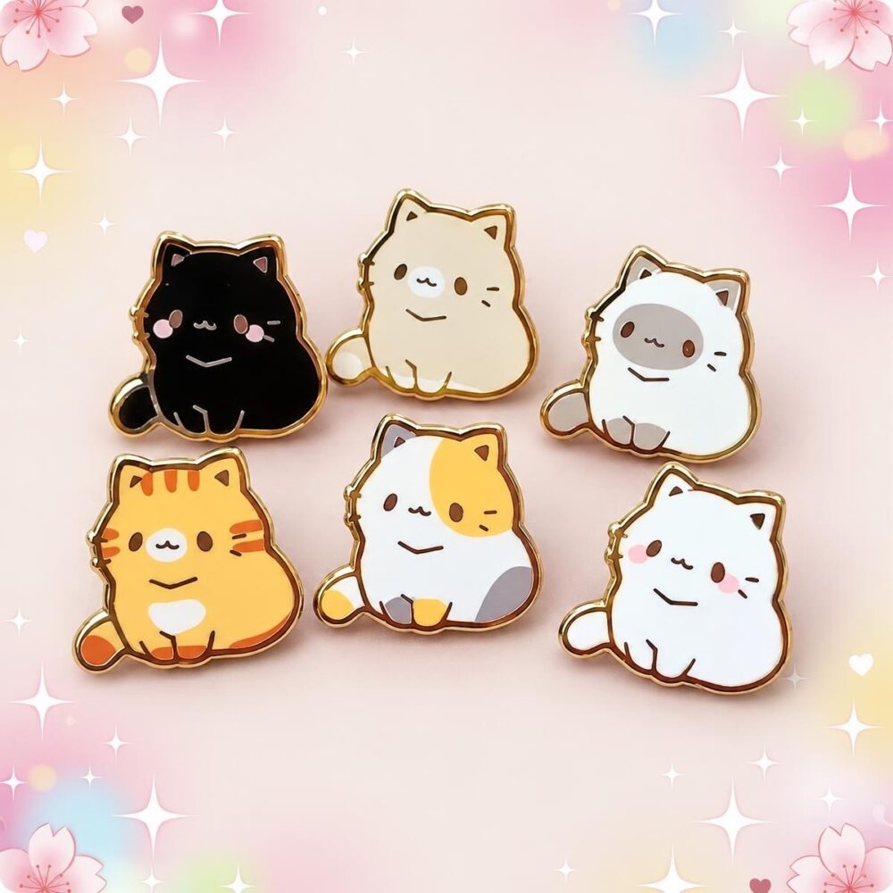 Un lot de 6 pins Kawaii en forme de chatons, aux couleurs variées, disposés sur un fond pastel décoré de fleurs et d’étoiles.
