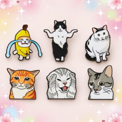 Un lot de 6 pins Kawaii aux chats amusants, représentant différents chats colorés, disposés sur un fond rose décoré de fleurs et d’étoiles.